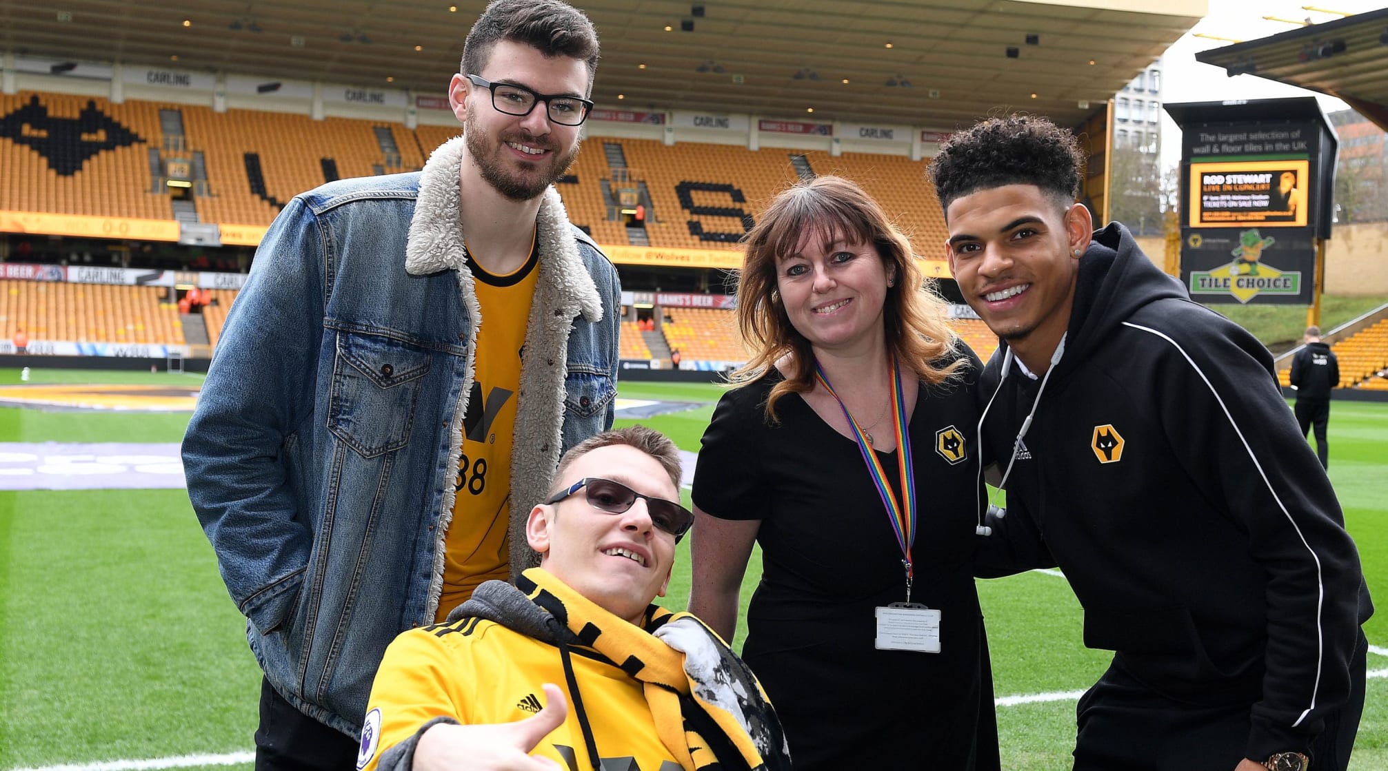 Laura Wright on the pitch at Wolves with a disabled fan, their friend and a Wolves first team player