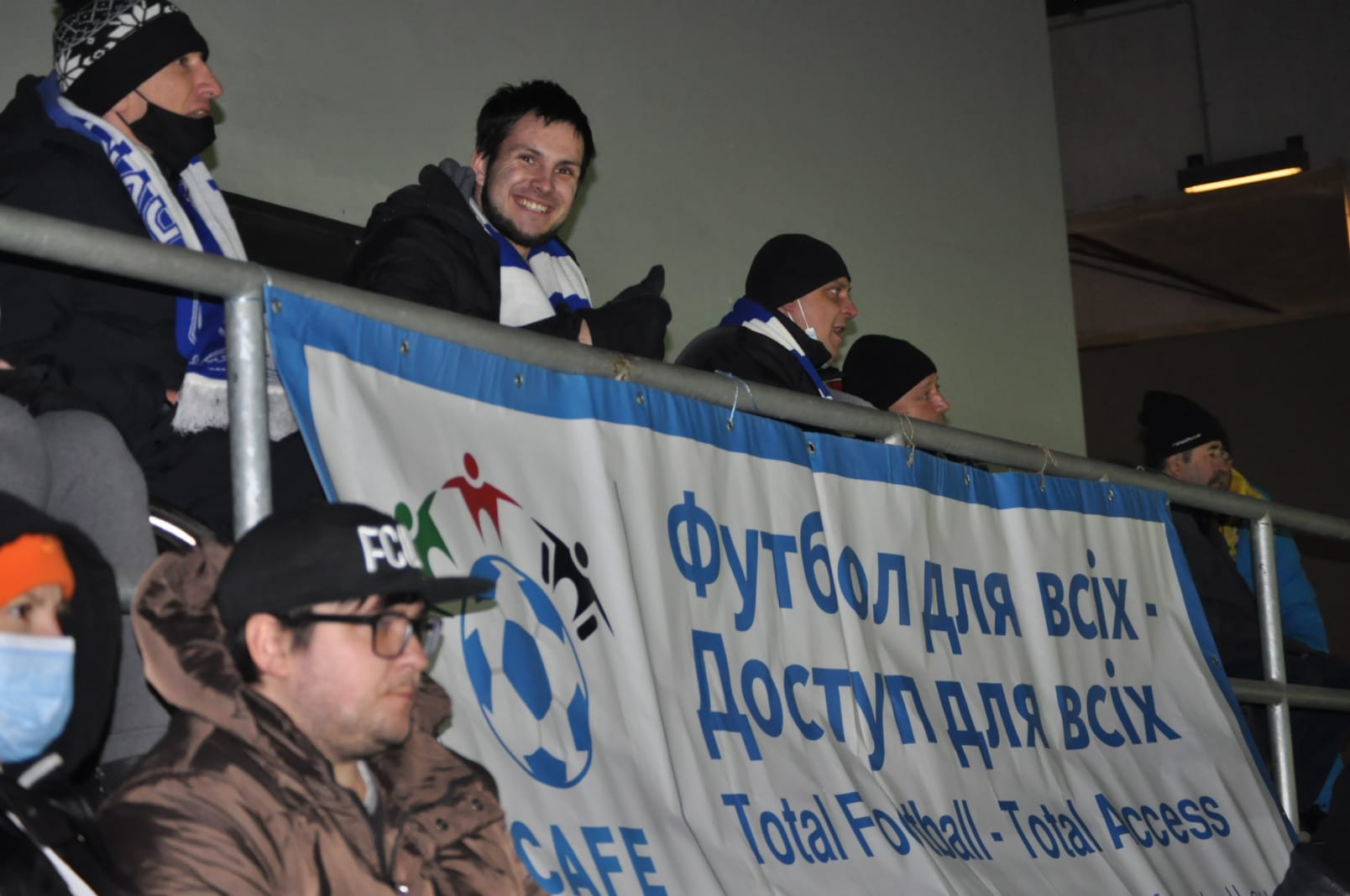 Disabled fans sit alongside a CAFE banner at a Dynamo Kyiv game. 